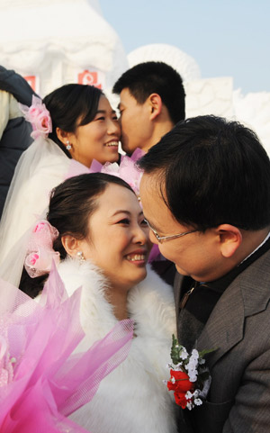 Couples kiss in a mass wedding ceremony on Sun Island of in Harbin, capital of China's northeast Heilongjiang Province, on Jan. 6, 2009. The 25th Harbin Mass Wedding Ceremony was held on Tuesday with 22 couple joined in. [Wang Jianwei/Xinhua]