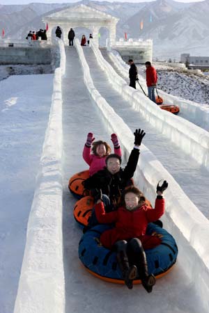 Tourists play on the slideway during the 4th Ice, Snow, Cultural and Tourism Festival in Barkol Kazak Autonomous County, northwest China's Xinjiang Uygur Augonomous Region, Jan. 5, 2009. 