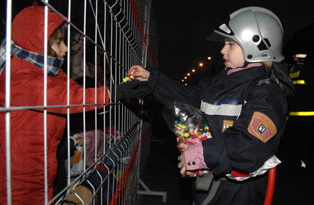 A boy taking part in the traditional Epiphany parade distributes sweets to others in Madrid, Spain, on Jan. 5, 2009. The annual Epiphany parade was held on Monday night. Traditionally, children in Spain get their Christmas presents from their parents on Jan. 6, the day when the 'Three Wise Men' visited the baby Jesus.[Chen Haitong/Xinhua]