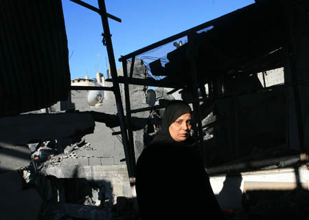 A Palestinian woman inspects rubbles after an Israeli airstrike in Rafah, southern Gaza Strip, Jan. 6, 2009. Israeli Prime Minister Ehud Olmert on Tuesday rejected a European Union (EU) request for a 48-hour ceasefire in the Gaza Strip, vowing to push ahead the offensive in the Gaza Strip till security is restored to southern regions of Israel. [Wissam Nassar/Xinhua]