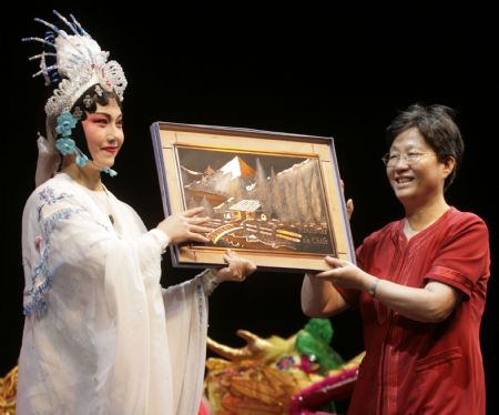 Chinese Ambassador to Chile Liu Yuqin (R) presents a gift to the performers of the Zhejiang Wuju Opera Troupe of China during the troupe's first performance in Santiago, capital of Chile, Jan. 5, 2009. The first performance attracted nearly 10,000 audience. [Xinhua]