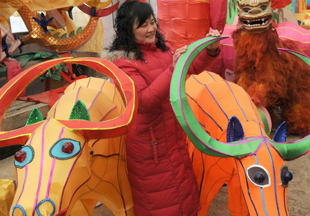A woman makes ox lanterns to welcome the Year of the OX in Kuisan village, East China's Shandong province Monday, January 5, 2009. [Xinhua] 