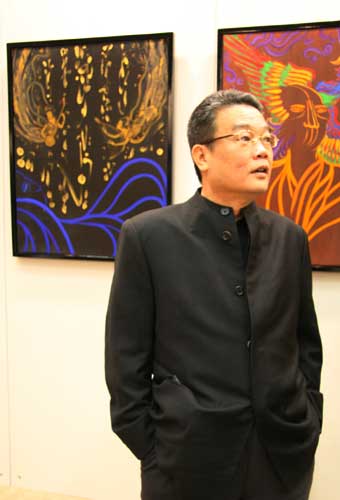 Artist Lee Sun-Don poses in front of his artwork at the Asian Art Top Show in Beijing on January 5th, 2009. Lee's 'Totemic Energy' oil paintings are representative of Buddhist teaching and ideals.
