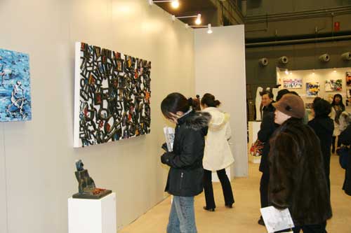Visitors view artworks at the Asian Art Top Show in Beijing on January 5th, 2009.