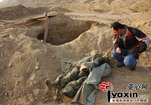 A construction worker watches an ancient corpse found in Turpan region in northwest China's Xinjiang Uygur Autonomous Region. He was one of the group who discovered five such mummified corpses. This photo was taken on Tuesday, January 6, 2009. 