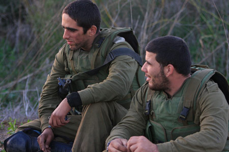 Two Israeli soldiers rest in the Gaza Strip Jan. 6, 2009. The Israeli army has said that it would hold fire in the Gaza Strip for three hours every day from Jan. 7 to allow local residents to prepare basic supplies. [Tsafrir Abayov/Xinhua]