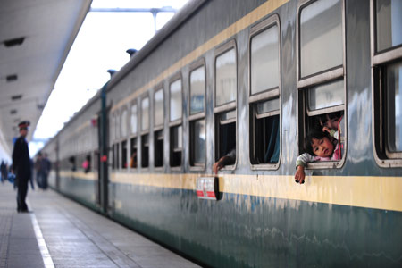 Little girl Wang Jiaxin (R), who is on her first journey back to her hometown for the upcoming Spring Festival, looks out from inside the carriage at the Guangzhou Railway Station in Guangzhou, capital of south China&apos;s Guangdong Province, Jan. 7, 2009. [Lu Hanxin/Xinhua]