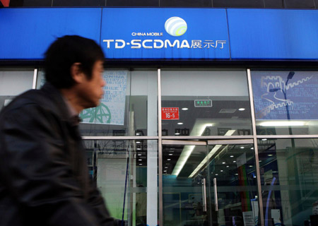 A man rides past a China Mobile exhibition hall in Beijing, China, Jan. 7, 2009. [Xinhua]