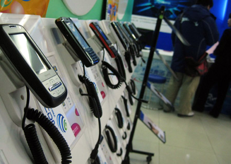 Customers try third-generation (3G) mobile phones at a China Mobile exhibition hall in Beijing, China, Jan. 7, 2009. China's telecommunications supervisor, the Ministry of Industry and Information Technology, on Wednesday issued the long-awaited third-generation (3G) mobile phone licenses to three mobile operators, namely China Mobile, China Telecom and China Unicom.[Xinhua]