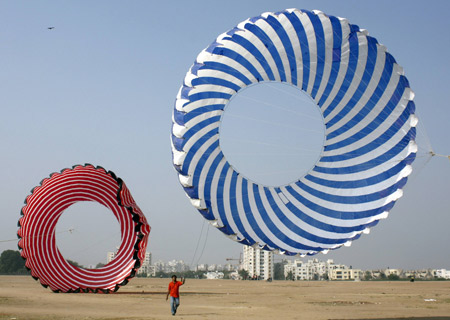 A kite-flying enthusiast tightens the strings of a 30 feet in diameter kite during a practice session ahead of the 19th International Kite festival in the western Indian city of Ahmedabad Jan. 7. 2009.[Xinhua/Reuters]