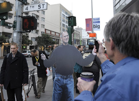 A man takes photos of the portrait of Apple's iconic CEO Steve Jobs, who has given the Macworld keynote address for the past 11 consecutive years but skipped this year's event, outside the meeting place of the Macworld Expo 2009 in San Francisco, the United States on Jan. 6, 2009. 