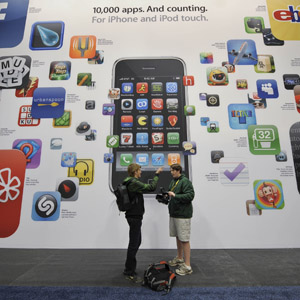 Visitors stand in front of a promo board at the Macworld Expo 2009 in San Francisco, U.S. on Jan. 6, 2009. [Qi Heng/Xinhua]