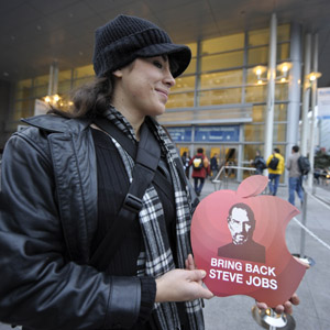 A woman carries a promo which printed with Apple's iconic CEO Steve Jobs, who has given the Macworld keynote address for the past 11 consecutive years but skipped this year's event, outside the meeting place of the Macworld Expo 2009 in San Francisco, the United States on Jan. 6, 2009. [Qi Heng/Xinhua] 