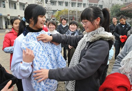 Two girl students who lost parents during the devastating earthquake hitting Sichuan on May 12, 2008 select donated sweaters at Tanghu High School in Dujiangyan City, southwest China's Sichuan Province, Jan. 6, 2009.[He Junchang/Xinhua] 