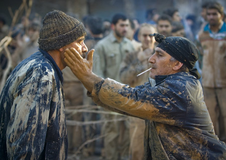 An Iranian man helps to smear mud on the face of another during the Ashura religious festival in Khorramabad, 491 km (307 miles) southwest of Tehran, Jan. 7, 2009. 