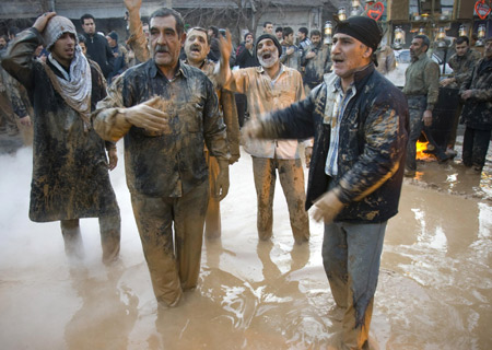 Iranian men covered in mud stand in a pool during the Ashura religious festival in Khorramabad, 491 km (307 miles) southwest of Tehran, Jan. 7, 2009. [Xinhua]