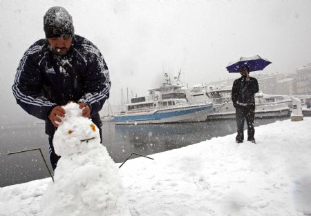 A man prepares a snowman on the Old Port after heavy snowfall in Marseille January 7, 2009. The usually busy and sunny Mediterranean port city ground to a halt as snow overwhelmed infrastructure and stopped school buses and all other public transport. [Xinhua/Reuters]