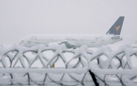 An airplane covered with snow is parked at Linate's airport in Milan January 7, 2009. Heavy snowfall forced northern Italy to close briefly its major airports on Wednesday, including Malpensa outside Milan. Linate city airport put a halt to flights until early afternoon. [Xinhua/Reuters]