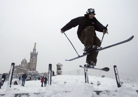 A man jumps with his skis in front of the Notre Dame de La Garde basilica after heavy snowfall in Marseilles January 7, 2009. The usually busy and sunny Mediterranean port city ground to a halt as snow overwhelmed infrastructure and stopped school buses and all other public transport. [Xinhua/Reuters]