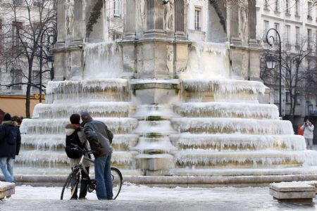 People look at the frozen fountain at the Place des Innocents as winter temperature fall below freezing point in Paris January 7, 2009. [Xinhua/Reuters]