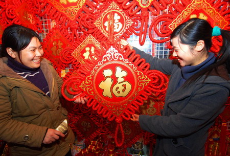 Two women select New Year decorations at a wholesale market in Yiwu, east China's Zhejiang province January 5, 2009. Chinese people are busy buying 'New Year necessities' - special purchases for the Spring Festival - and decorations in preparations for get-togethers during the traditional Chinese festival, which starts on January 26 this year according to Chinese lunar calendar. 