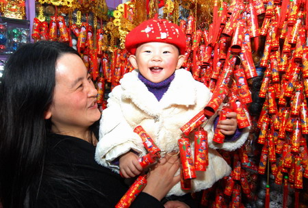 A mother and child select New Year decorations at a market in Yiwu, east China's Zhejiang province January 5, 2009. Chinese people are busy buying 'New Year necessities' - special purchases for the Spring Festival - and decorations in preparations for get-togethers during the traditional Chinese festival, which starts on January 26 this year according to Chinese lunar calendar. 