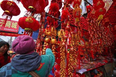 A woman selects New Year decorations at a market in Wuhan, central China's Hubei province January 5, 2009. 