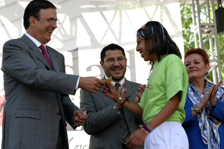 Mexico City Mayor Marcelo Ebrard (L) gives a free ticket card to a student in Mexico City, capital of Mexico, Jan. 7, 2009. The government of Mexico City on Wednesday presented to college students 9,000 free ticket cards for public transportation. [Ma Guoqiang/Xinhua]