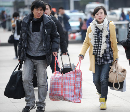 People carry baggages as they walk on the square of the Changsha Railway Station in Changsha, capital of central-south China's Hunan Province, Jan. 8, 2009. The Spring Festival travel period, known as Chunyun in Chinese, began to see its passenger peak in Changsha as the college students and migrant workers started to return home. [Li Ga/Xinhua]