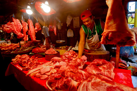 A meat vendor sells pork at a market in Manila, capital of the Philippines, Jan. 8, 2009. A team of international experts is investigating the Ebola Reston virus found in pigs at two farms in the northern Philippines, the World Health Organization (WHO) said on Thursday. [Luis Liwanag/Xinhua]