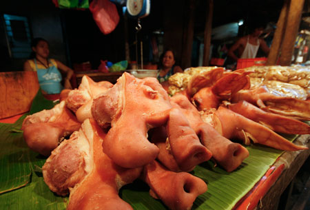 Vendors sell pork at a market in Manila, capital of the Philippines, Jan. 8, 2009. A team of international experts is investigating the Ebola Reston virus found in pigs at two farms in the northern Philippines, the World Health Organization (WHO) said on Thursday. [Luis Liwanag/Xinhua]