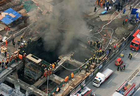 Rescuers work at the construction site on Line 11 where a fire broke out in Shanghai, east of China, Jan. 8, 2009. The fire broke out 20 meters underground at the construction site, killing one worker and injuring six others, according to the fire brigade.[Chen Fei/Xinhua]
