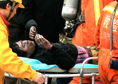 An injured person is rescued at the construction site on Line 11 where a fire broke out in Shanghai, east of China, Jan. 8, 2009. The fire broke out 20 meters underground at the construction site killing one worker and injuring six others, according to the fire brigade.[Chen Fei/Xinhua] 