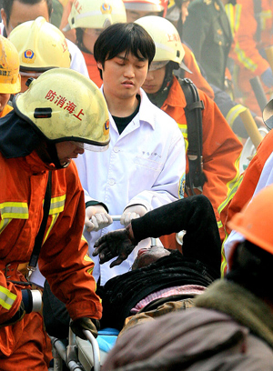  An injured person is rescued at a construction site of subway line 11 where a fire broke out in Shanghai, east of China, Jan. 8, 2009. The fire broke out 20 meters underground at the construction site, killing one worker and injuring six others, according to the fire brigade. [Chen Fei/Xinhua]