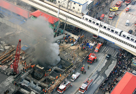 Smoke rises from a construction site of subway line 11 in Shanghai, east of China, Jan. 8, 2009. The fire broke out 20 meters underground at the construction site, killing one worker and injuring six others, according to the fire brigade. [Chen Fei/Xinhua]