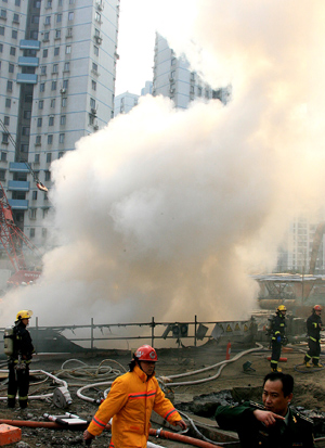 Smoke rises from a construction site of subway line 11 in Shanghai, east of China, Jan. 8, 2009. The fire broke out 20 meters underground at the construction site, killing one worker and injuring six others, according to the fire brigade. [Chen Fei/Xinhua]