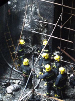 Rescuers work at the fire site of a construction site of subway line 11 in Shanghai, east China, Jan. 8, 2009. The fire broke out 20 meters underground at the construction site, killing one worker and injuring six others, according to the fire brigade. [Xinhua]