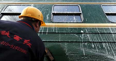 A worker cleans a train at the Changsha Railway Station in Changsha, capital of central-south China's Hunan Province, Jan. 8, 2009. The Spring Festival travel period, known as Chunyun in Chinese, will start officially on Jan. 11. Some 30 temporary trains are ready in Changsha as the preparation work is in place to ensure the safe and orderly operation during the peak travel season. [Zhao Zhongzhi/Xinhua]