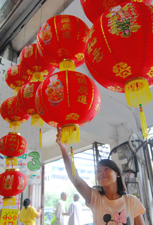 A girl picks red lanterns at the Chinatown in Jakarta, captial of Indonesia, on Jan. 8, 2009. [Yue Yuewei/Xinhua]
