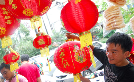  A man picks red lanterns at the Chinatown in Jakarta, captial of Indonesia, on Jan. 8, 2009. [Yue Yuewei/Xinhua]
