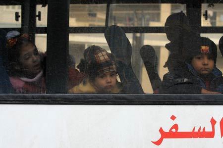  Palestinian children with dual citizenship look out of a bus as they leave the Gaza Strip with family Jan. 8, 2009.[Wissam Nassar/Xinhua]