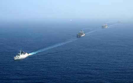 Merchant vessels sail in a line formation under command of the DDG-169 Wuhuan destroyer in the Gulf of Aden, January 6, 2009. [Xinhua] 