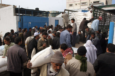 Palestinian refugees receive food in aid from an office of the United Nations in Gaza city, Jan. 8, 2009.[Xinhua]