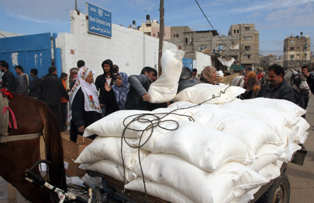 Palestinian refugees receive food in aid from an office of the United Nations in Gaza city, Jan. 8, 2009.[Xinhua]