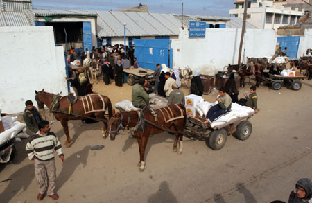 Palestinian refugees receive food in aid from an office of the United Nations in Gaza city, Jan. 8, 2009.[Xinhua]