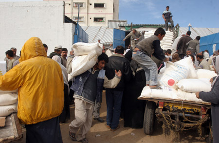 Palestinian refugees receive food in aid from an office of the United Nations in Gaza city, Jan. 8, 2009.[Xinhua]