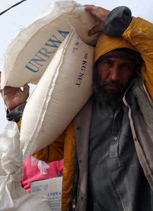 Palestinian refugees receive food in aid from an office of the United Nations in Gaza city, Jan. 8, 2009.[Xinhua]