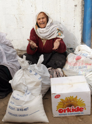  A Palestinian female refugee receives food in aid from an office of the United Nations in Gaza city, Jan. 8, 2009.[Xinhua]