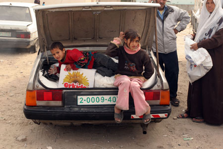 Palestinian refugees receive food in aid from an office of the United Nations in Gaza city, Jan. 8, 2009.[Xinhua]