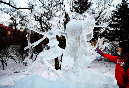 A visitor looks at an ice sculpture during the 23rd International Ice Sculpture Competition in Harbin, Northeast China's Heilongjiang Province, January 8, 2009. About 60 competitors from 12 countries and regions took part in this event which concluded on Thursday. [Xinhua] 